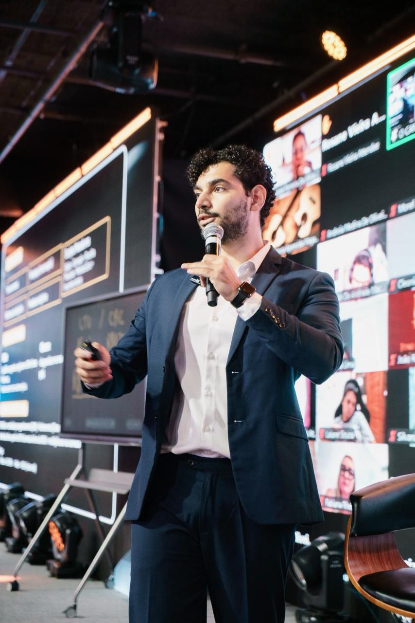 Rodrigo Melville em palestra, apresentando indicadores no palco